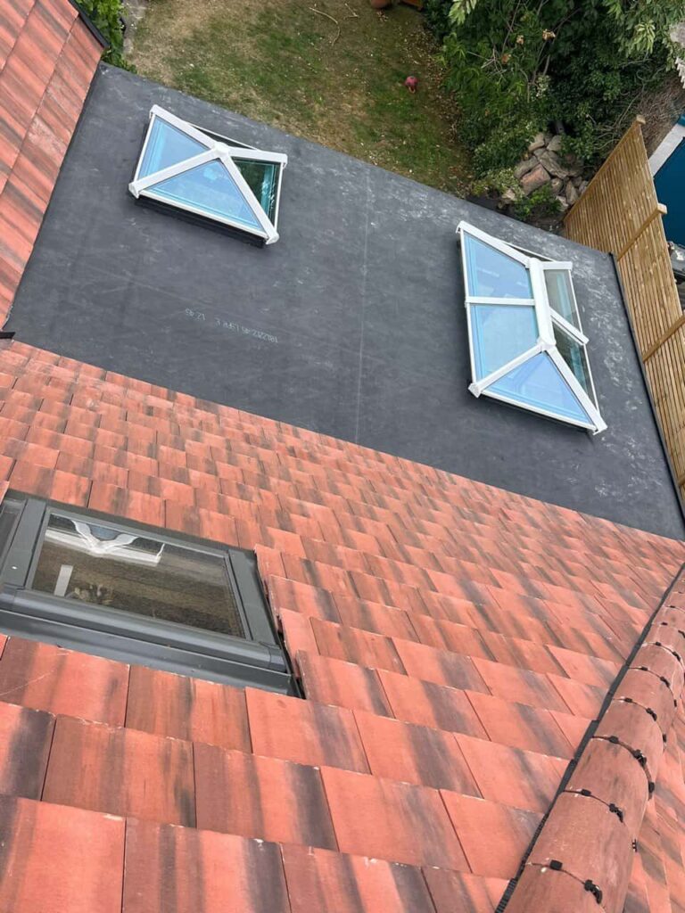This is a photo taken from the roof ridge looking down a tiled pitched roof on to a flat roof. Works carried out by LJ Roofing Carterton